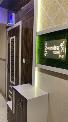 the entrance to an office building with artificial grass on the walls and door panels,