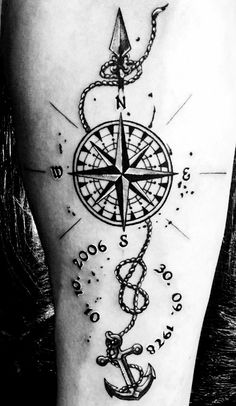 a black and white photo of a tattoo with an anchor, compass and chain on it