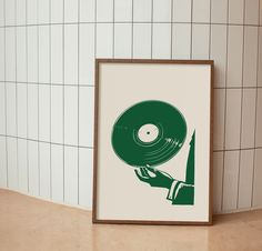 a green vinyl record being held by a person's hand in front of a tiled wall