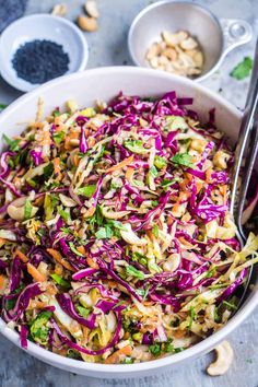 a white bowl filled with coleslaw and nuts