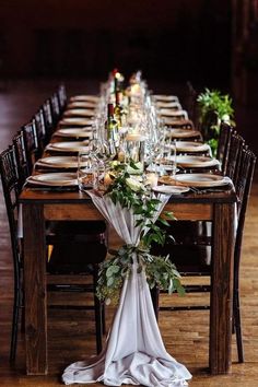 the table is set with candles and greenery