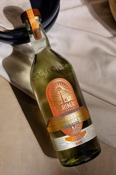 a bottle of wine sitting on top of a table next to a plate and bowl