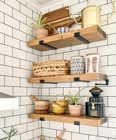 two wooden shelves filled with pots and pans on top of a white tiled wall