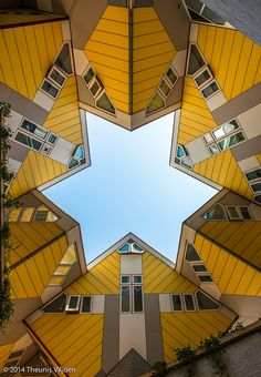 the view from below looking up at an upside down building with yellow and white windows