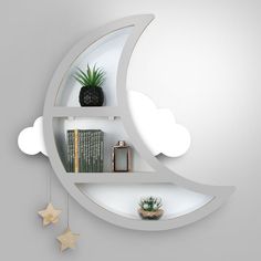 the moon shelf is decorated with books and plants on it's shelves, along with other decorative items