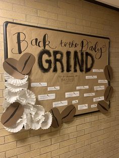 a bulletin board with paper flowers on it and the words back to the day grind