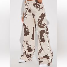 Sand/Combo. Wide Leg Pant Front Screen Abstract Print Oversized/Baggy Oversized Beige Bottoms For Fall, Oversized Beige Pants For Spring, Beige Loose-fit Sweatpants For Spring, Trendy Khaki Bottoms For Loungewear, Beige High Waist Relaxed Fit Sweatpants, High Waist Beige Relaxed Fit Sweatpants, Trendy Cream Wide Leg Pants, Trendy Brown Wide Leg Pants With Relaxed Fit, Trendy Cream Relaxed Fit Bottoms