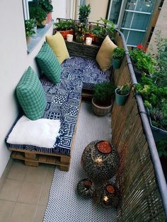 an outdoor patio with potted plants and pillows