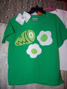 a green t - shirt with an image of a fish and eggs on the front