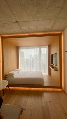 a room with a bed, television and window in the wall that is lit up