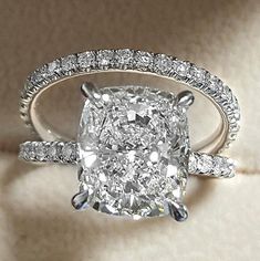 a cushion cut diamond ring with two rows of diamonds around it