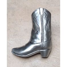 a pair of silver cowboy boots sitting on top of a floor