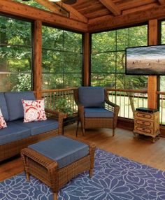 a living room filled with furniture and a flat screen tv on top of a wooden wall