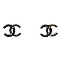 These Chanel CC two-tone stud earrings are of dark grey ruthenium and light gold tone hardware, features two tone interlocking CC logo studs with post back closures.Origin: FranceCondition: Pre-owned; Mint - There's visible scratches to the front of the earrings.Accompanied by: Chanel jewelry boxMeasurements: .95" x .62" Designer Formal Jewelry With Metal Logo, Designer Black Round Earrings, Luxury Silver Earrings With Black Enamel, Chanel Earrings Studs Silver, Chanel Earrings Cheap, Chanel Earrings Cc, Chanel Large Cc Earrings, Chanel Earrings Classic, Chanel Jewelry