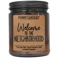 a candle that says welcome to the neighborhood with a brown label on it's front