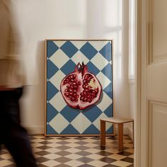 a pomegranate on a blue and white checkered wall in a room