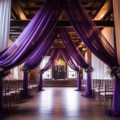 an indoor wedding venue with purple draping