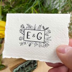 a person holding up a piece of paper with the letter eg on it