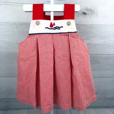 Vintage strapless dress with red & white striped skirt. White chest panel with red sailboat design with blue water. Clear buttons on red straps.  Size: No size tag but looks around 12-18 months. See measurements below to ensure fit. Measurements (approximate): Shoulder to Hem: 15.5" Armpit to Armpit: 12.5" Condition: Spot and run on skirt. Some light yellowing on one side of top. Hem looks hand stitched, not sure if it was adjusted. See pictures for details. Be sure to check out my shop! New items added often! https://www.etsy.com/shop/AutumnRoseArtVintage Red Sailboat, Sailboat Design, White Chest, Nautical Dress, White Striped Skirt, White Chests, Striped Skirt, Skirt White, Sailboats