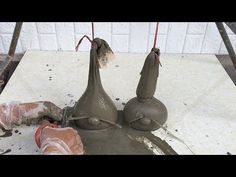 two vases sitting on top of a cement slab next to a red object with wires hanging from it