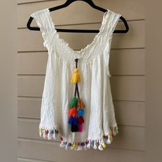 Size Xl Love J Brand New Bohemian Style Too Sleeve Can Be Styled In Multiple Ways, Off The Shoulder Or Sleeveless Top Colorful Big Tassel In The Middle And Lower Rim With Colorful Details White Cotton Top With Back Tassel Tie-up, Sleeveless Fringe Top For Beach Season, Casual Summer Tops With Back Tassel Tie-up, Sleeveless Beach Tops With Tassels, Casual Beach Tops With Tassels, Sleeveless Tassel Top For Beach, Casual Sleeveless Top With Tassel Ties, Cotton Beach Tops With Tassels, Beach Cotton Tops With Back Tassel Tie-up