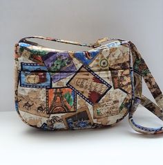 "This cute print has \"snapshots\" of different travel destinations; Statue of Liberty, Eiffel Tower, Japan and camels.  Also pics of luggage, airplanes and more. There is a large double pocket on the outside and four pockets inside. It has an adjustable strap that extends to 52\". The purse is made of cotton fabric with a quilted lining. The bag has a zipper closing and all seams are covered with extra wide double fold seam binding. The base is cotton covered plastic and is removable. Approxima Casual Rectangular Travel Accessories With Zipper Pocket, Casual Travel Accessories With Zipper Pocket, Retro Travel Shoulder Bag With Pockets, Retro Shoulder Bag With Pockets For Travel, Vintage Travel Bag With Multiple Pockets, Retro Travel Bags With Pockets, Rectangular Travel Accessories With Pockets, Rectangular Travel Accessories With Pockets For Trips, Multicolor Travel Shoulder Bag With Pockets