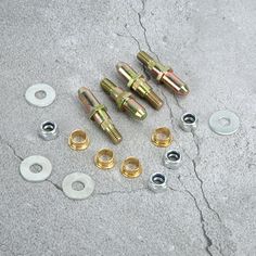 several nuts and washers are laying on the ground next to each other with screws in them