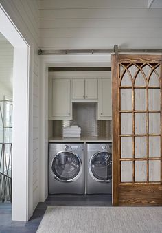 a washer and dryer in a room next to each other with doors open