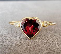 1. Garnet 18k Gold Ring 2. Stamped 3. Gemstone - Garnet, Diamond  4. Jewelry Type - Gold Ring 5. Total Weight - 1.560 Grams Approx. 6. Garnet Weight - 1.56 Carats 7. Diamond Weight - 0.04 Carats  8. Gold Weight - 1.240 Grams Approx. 9. Garnet Size - 7x7 MM 10. Gold Purity - 18k 11. Band Size - 1 MM 12. Handmade Items 13. AAA Quality Ring 14. Stackable Ring 15. 1 Quantity Available 16. Ready to Dispatch in 1 - 2 days. 17. Natural Red Garnet   Pictures are taken under natural and day light. Elegant Heart Cut Heart Ring For Anniversary, Heirloom Ruby Ring Gift For Valentine's Day, Classic Jewelry With Bezel Setting For Valentine's Day, Gift Yellow Gold Ruby Ring With Gemstone Accents, Gift Ruby Ring In Yellow Gold With Gemstone Accents, Fine Jewelry With Bezel Setting For Valentine's Day, 14k Gold Jewelry With Bezel Setting For Valentine's Day, Yellow Gold Jewelry With Halo Setting For Valentine's Day, Valentine's Day Yellow Gold Jewelry With Accent Stones