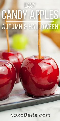 three candy apples with toothpicks in them on top of a tray and text overlay that says easy candy apples, autumn & halloween