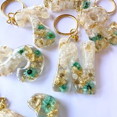 several pieces of glass with gold and green accents on white surface next to each other