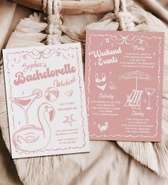 two pink and white wedding cards on top of a bed next to a wooden chair