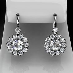 Women's drop/dangle earrings containing 2 forever brilliant moissanite center stones and 22  natural brilliant cut diamonds.EARRINGS DESCRIPTION Style # KE-3105Material - 14K , 18K White Gold/ 14K, 18K Yellow Gold/ 14K, 18K Rose Gold/ Platinum-price upon request.Moissanite cut- roundMoissanite size -  approx. 5.0x5.0mm Diamonds cut - roundDiamonds Color- approx G/HClarity approx - VS2/SI1Diamonds weight - approx 0.86 carat total weight for both earrings.You can find ring measurements on the blue Antique Style Jewelry, Diamond Cluster Earrings, Jewelry Appraisal, Detailed Jewelry, Peoples Jewellers, Saree Trends, Round Moissanite, Earrings In Gold, Custom Earrings