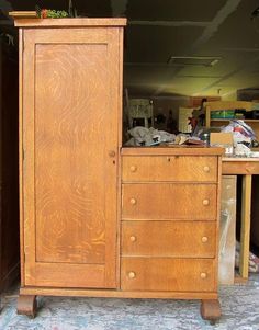 an old wooden armoire sitting in the middle of a room next to a desk