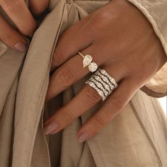 a close up of a person's hand with three rings on their fingers and one ring in the middle