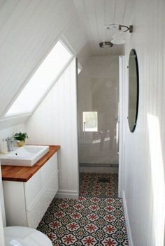 a bathroom with a sink, toilet and shower in it's attic style home