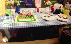 a blue and white table topped with cakes and cupcakes