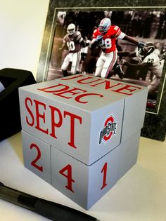 a box that is sitting on a table next to a pen and some pictures in the background