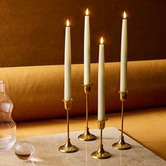 three candles are lit on a marble table