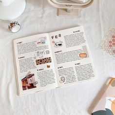 an open book sitting on top of a bed next to other items and decors