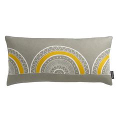 a grey and yellow pillow with circles on the front, along with a white background