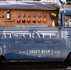 an old blue truck is parked in front of a building with beer taps on it