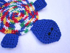 a crocheted turtle toy laying on top of a white surface