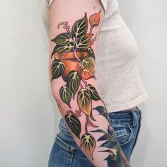 a woman with a tattoo on her arm has a plant growing out of the side of her arm