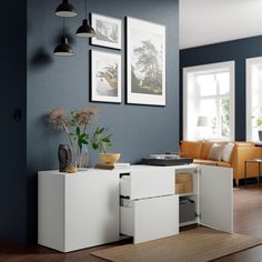 a living room with blue walls and white furniture