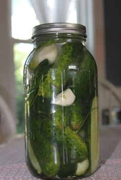 pickles and onions in a mason jar on a table