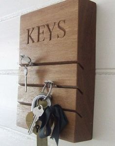 a wooden key holder with keys attached to it