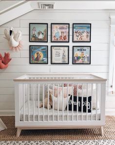 a white crib with posters on the wall