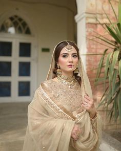 a woman in a bridal outfit posing for the camera