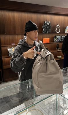 a man holding a purse in front of a display case